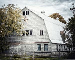 The image is a set of four framed photographs depicting various white barns.