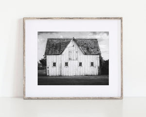 The image is a set of six framed pictures depicting various farm buildings, including barns and silos, arranged in a grid on a wall.