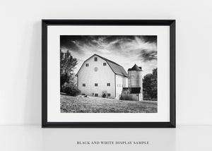 The image is a set of four framed photographs depicting various white barns.
